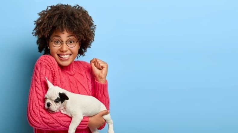 Uma jovem feliz segura o seu cão Uma jovem feliz segura o seu cão